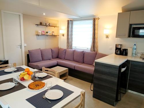 a living room with a purple couch and a table at Océan Mobilhome Siblu Bonne Anse Village Vacances La Palmyre in Les Mathes