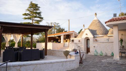 a patio with black chairs and a building at Trulli Magnolia in Putignano