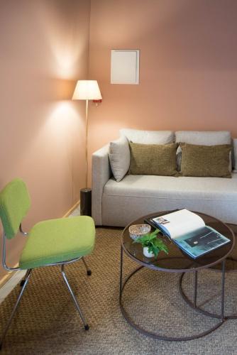 a living room with a couch and a table and chairs at Green&Houses in Ponta Delgada