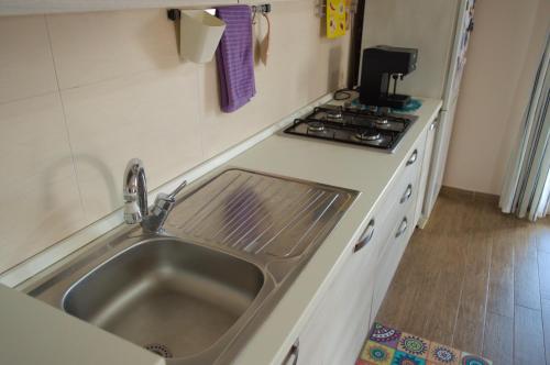 a kitchen with a sink and a stove at Peppe's house in Gravina di Catania
