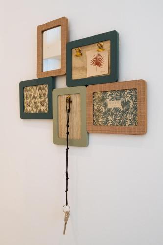 a wall with wooden frames and a clock on it at BeHappy Apartments in Lisbon