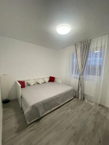 Chiajna的住宿－Apartament cu loc de parcare，白色的卧室设有床和窗户