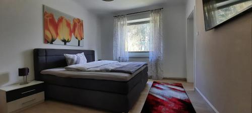 ein kleines Schlafzimmer mit einem Bett und einem Fenster in der Unterkunft Ferienhaus im Grünen/Monteurzimmer in Oranienburg