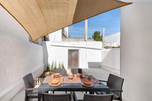 patio con mesa y sillas en el balcón en Appartamento Dada, en Carmiano
