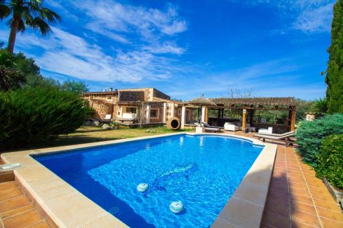 an image of a swimming pool in front of a house at Incredible villa with wonderful exteriors in Sencelles