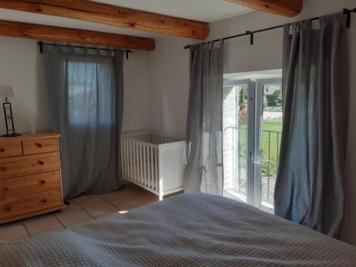 1 dormitorio con cama y ventana grande en Gite du riage, en Saint-Christol-lès-Alès