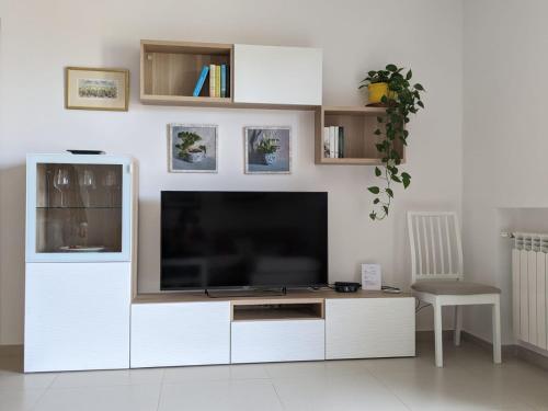 een groot wit entertainmentcentrum met een grote flatscreen-tv bij La Casa dei Due Mari - large apartment with parking in Taranto