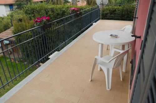 een balkon met een tafel, stoelen en bloemen bij Peppe's house in Gravina di Catania