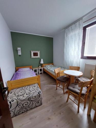 a bedroom with two beds and a table and chairs at HostelChe Guest House in Smederevo