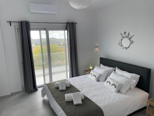 1 dormitorio con 1 cama blanca grande y ventana en Villa Phos, en Káthikas