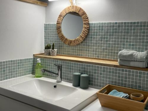 a bathroom with a sink and a mirror at un oasis au coeur de la vieille ville, classé 4 étoiles in Montpellier