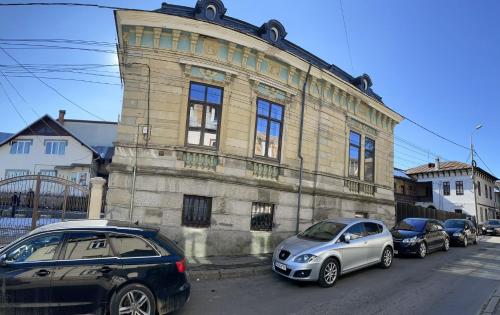 a group of cars parked in front of a building at Casa Continentelor in Câmpulung