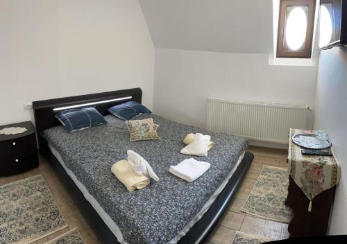a bedroom with a bed with towels on it at Casa Continentelor in Cîmpulung