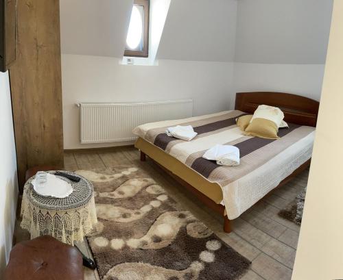 a bedroom with a large bed and a table at Casa Continentelor in Câmpulung