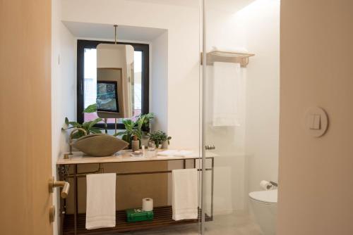 een badkamer met een wastafel en een spiegel bij Green&Houses in Ponta Delgada
