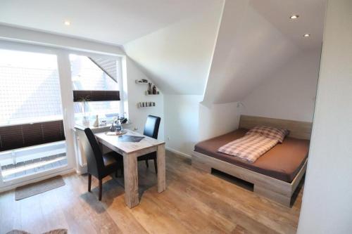 una camera con letto, scrivania e tavolo di Appartementhaus-Kogge-Wohnung-8 a Cuxhaven