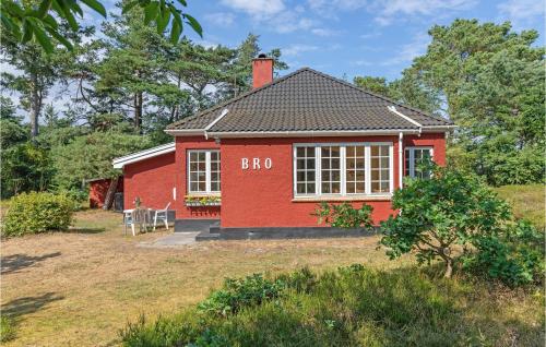 a red house with a large window in a yard at Nice Home In Nexø With Wifi in Neksø