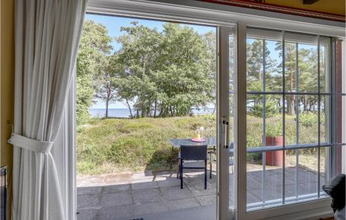 a sliding glass door leading to a patio with a table at Nice Home In Nexø With Wifi in Neksø