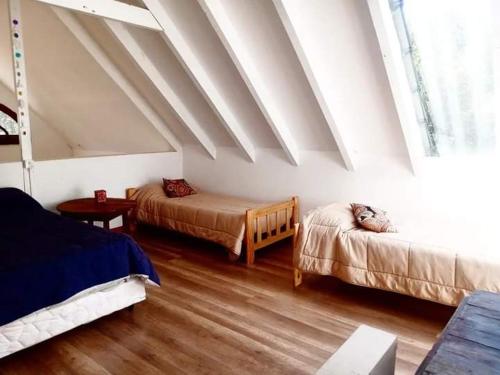 una camera con due letti e un soffitto spiovente di Cabañas BASTIÓN a Villa La Angostura
