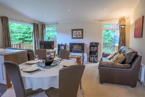 a dining room and living room with a table and chairs at Conkers Retreat at Finlake Resort & Spa, Devon in Chudleigh