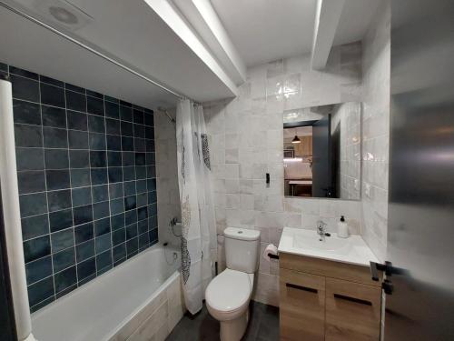 a bathroom with a toilet and a sink and a tub at Loft 4 MORELLA in Morella