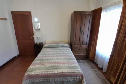 a small bedroom with a bed and a dresser at Monoambiente en zona central norte in Cochabamba