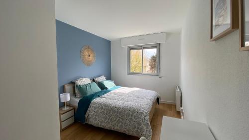 a bedroom with a bed and a window at LE CYLIA in Mérignac