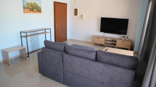 uma sala de estar com um sofá e uma televisão de ecrã plano em el greco apartment in Ilha de Rhodes