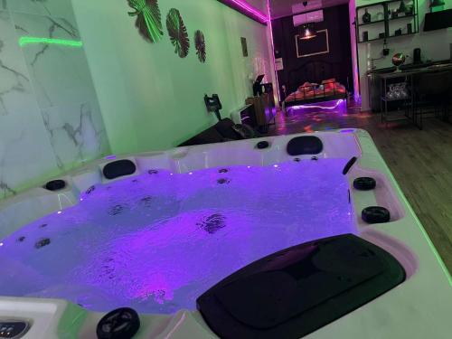 bañera de hidromasaje con agua púrpura en una habitación en Love room chez Adan, en Arles