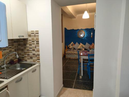 uma cozinha com um lavatório e uma mesa com um sofá em La casa di Zahra em Riccò del Golfo di Spezia