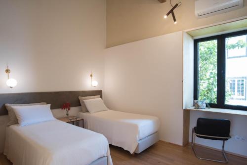 a hotel room with two beds and a window at Green&Houses in Ponta Delgada