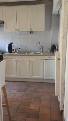 une cuisine avec des armoires blanches et un évier dans l'établissement charme et confort au coeur du vieux Tours, à Tours