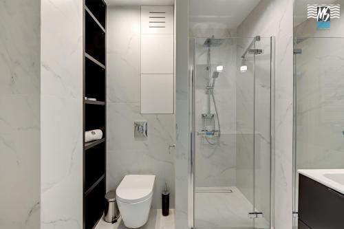 a bathroom with a shower and a toilet and a sink at MS Apartments Rest 5.0 in Sopot