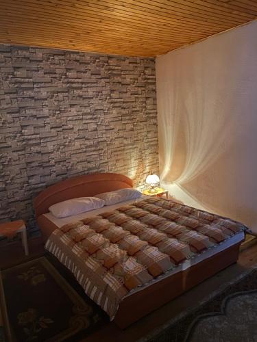 1 dormitorio con cama y pared de ladrillo en Stolac Home River, en Stolac