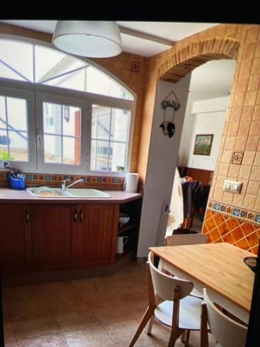 a kitchen with a sink and a table with a dining room at Casa de Pueblo en Navarres in Navarrés