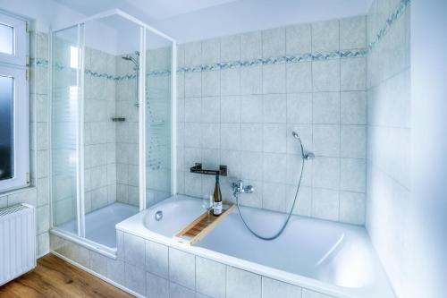 biała łazienka z wanną i prysznicem w obiekcie Levax Living - Cozy - Clarapark - citynah w Lipsku
