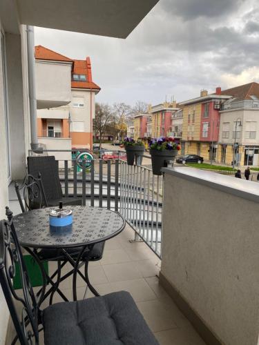 een patio met een tafel en stoelen op een balkon bij Happy Seasons Szoboszló in Hajdúszoboszló
