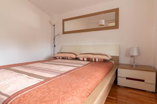 1 dormitorio con 1 cama con espejo en la pared en Modern Apartment Sara-near the beach, en Privlaka