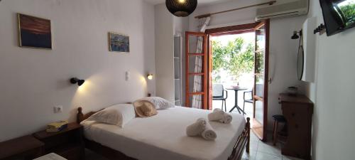 1 dormitorio con 1 cama con toallas en Kapetanos Rooms, en Naxos Chora