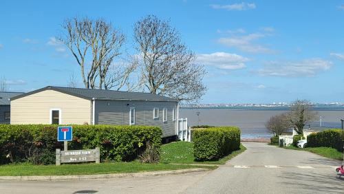 a house on the side of a road next to the water at Kent Coast 3 bedroom holiday home in Rochester