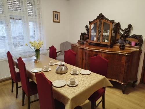 a dining room with a table and chairs and a mirror at Tartós Szegfű Vendégház, Magánszállás in Tázlár