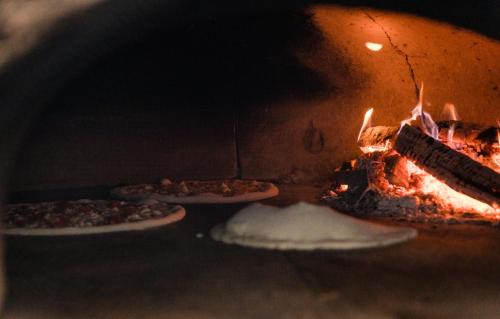 two pizzas are being cooked in an oven at Casa Del Sole in Alba Iulia
