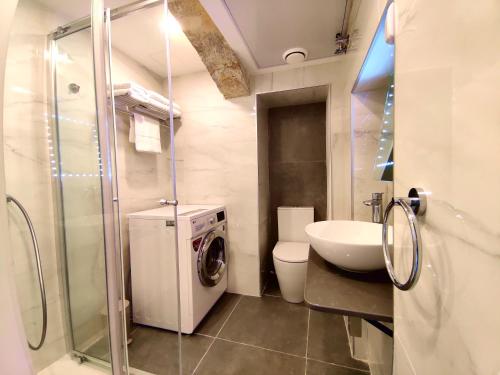 un bagno con lavatrice e lavandino di Tide 21 Savynomad Harbour Residences Valletta a La Valletta