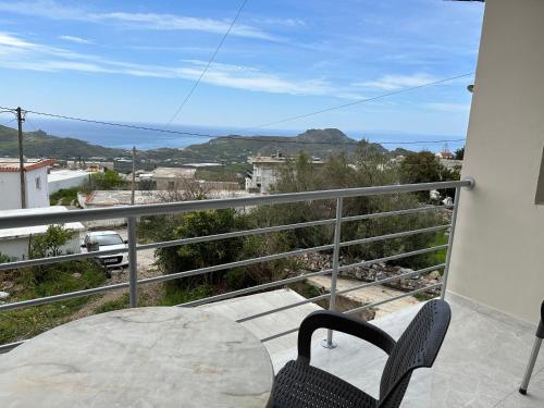 a balcony with a table and chairs and a view of the ocean at Angel Homes in Plakias