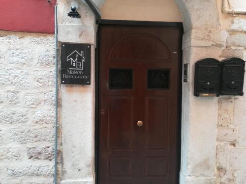 a brown door with a sign on the side of a building at Maison Brancaleone in Barletta