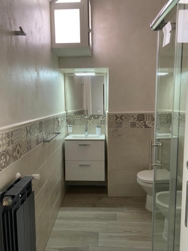 a bathroom with a sink and a toilet and a window at Maison Brancaleone in Barletta