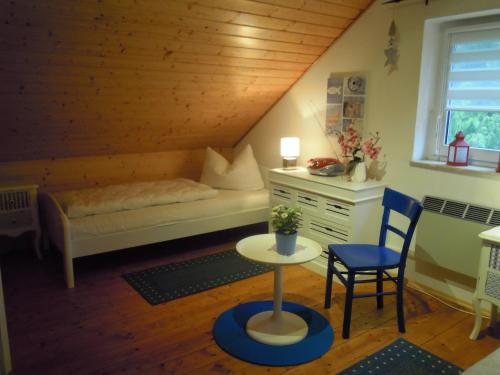 ein Schlafzimmer mit einem Bett, einem Tisch und einem Stuhl in der Unterkunft Ferienhaus am Fleesensee in Silz