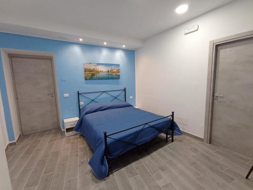 a bedroom with a bed with a blue wall at B&B San Giacomo in Paola