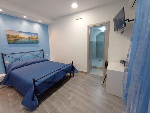 a bedroom with a blue bed and a bathroom at B&B San Giacomo in Paola