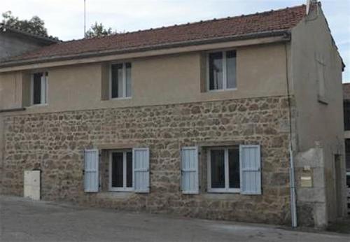 une maison en brique avec volets blancs dans l'établissement Beau logement 4 chambres, à Roisey